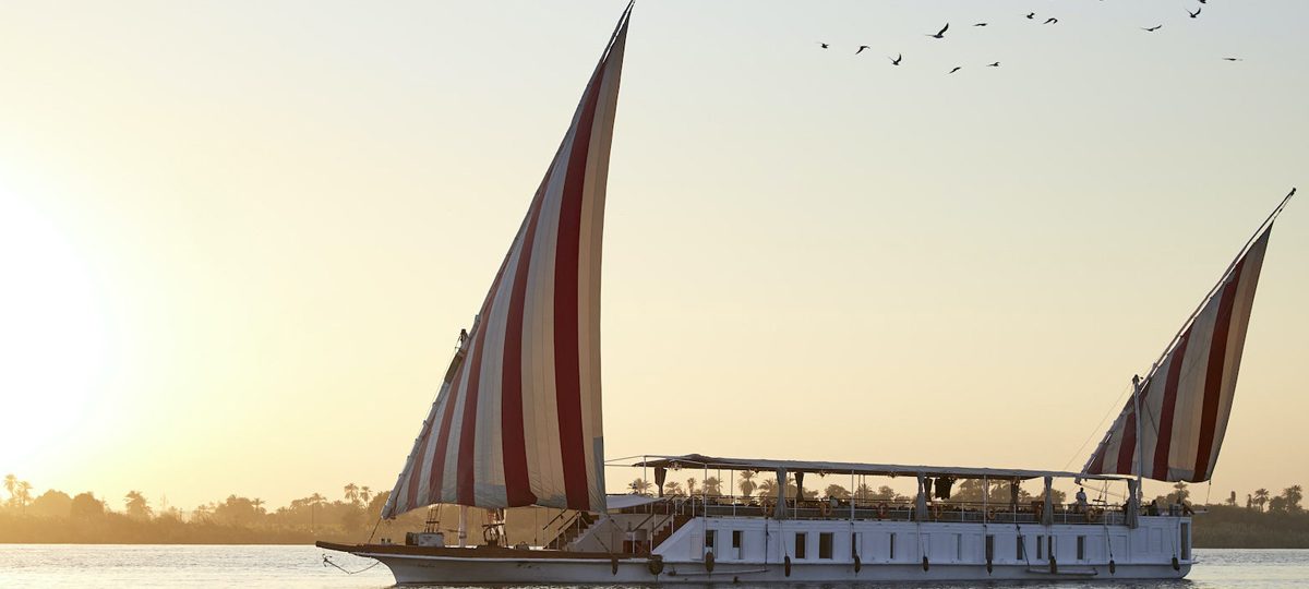 A dahabiya is a traditional wooden sailing boat commonly used on the Nile River, especially for leisurely cruises between Luxor and Aswan. Characterized by its elegant design and spacious decks, a dahabiya typically features: